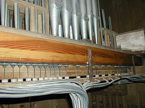 fragment wnętrza szafy instrumentu - widoczna część piszczałek i traktury